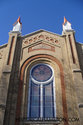 Front Of Church With Two Spires And Stained Glass Windows