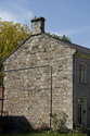 Side Of Historic Stone Block House With Side Chimney